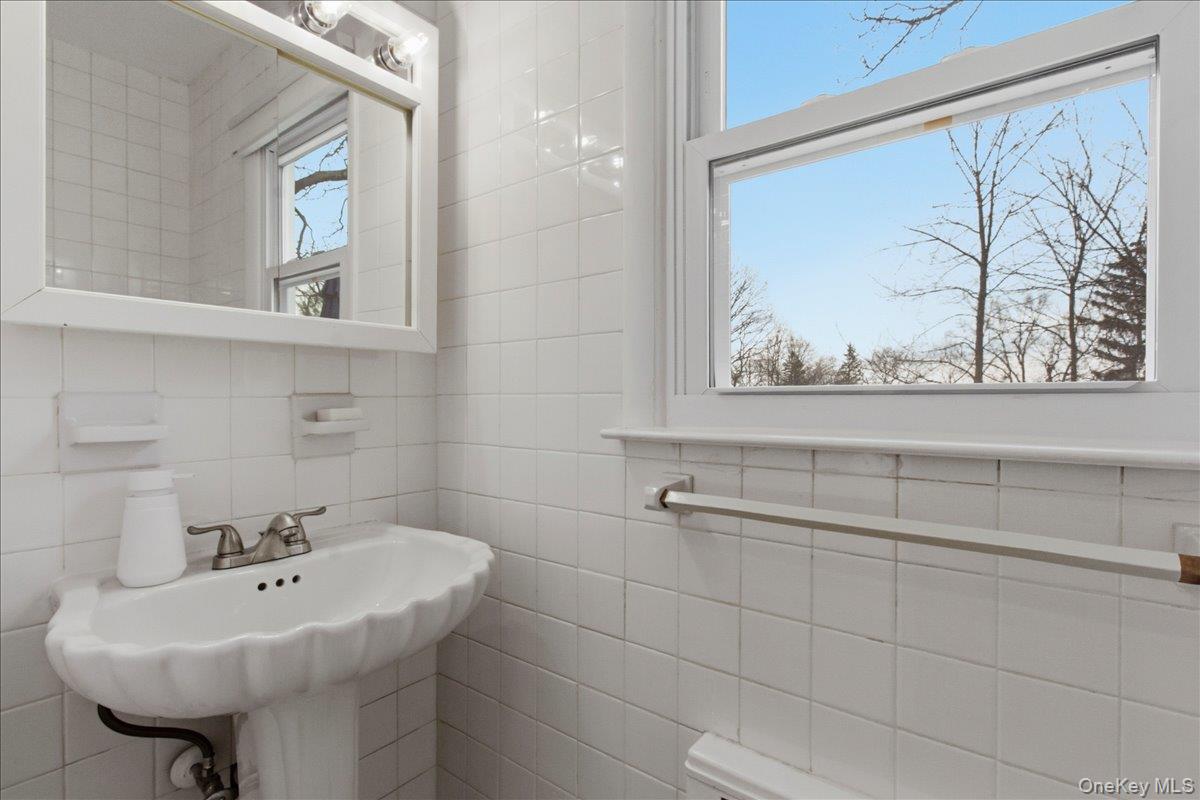 169 Canterbury Road White Plains, NY 10607 - Photo 10 of 27 a bathroom with a sink a mirror and a shower