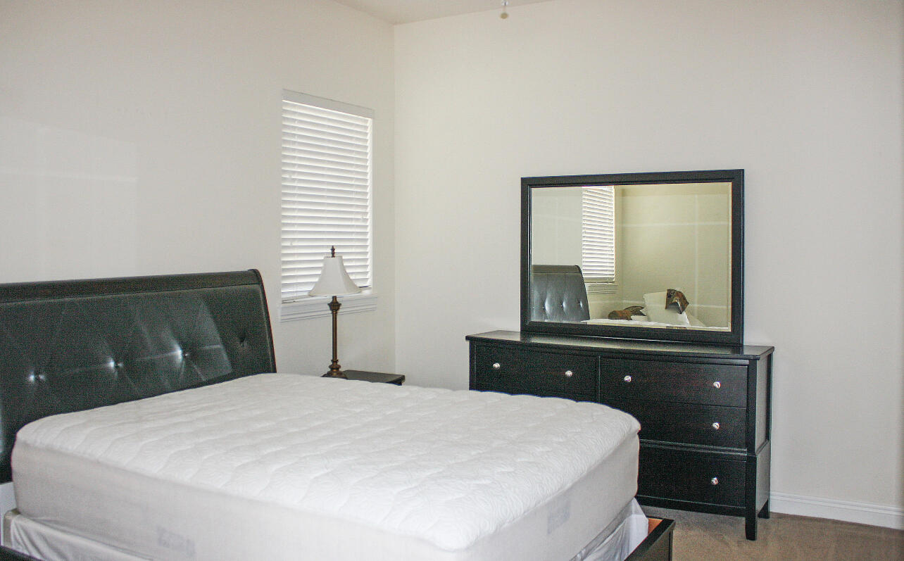 113 Inkberry Drive Jupiter, FL 33458 - Photo 2 of 4 a bedroom with a bed and a dresser
