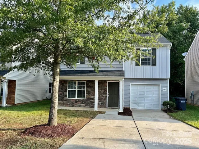 a front view of a house with a garden and yard