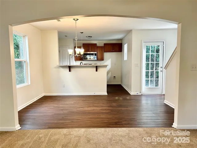 a view of a kitchen with wooden floor and a kitchen