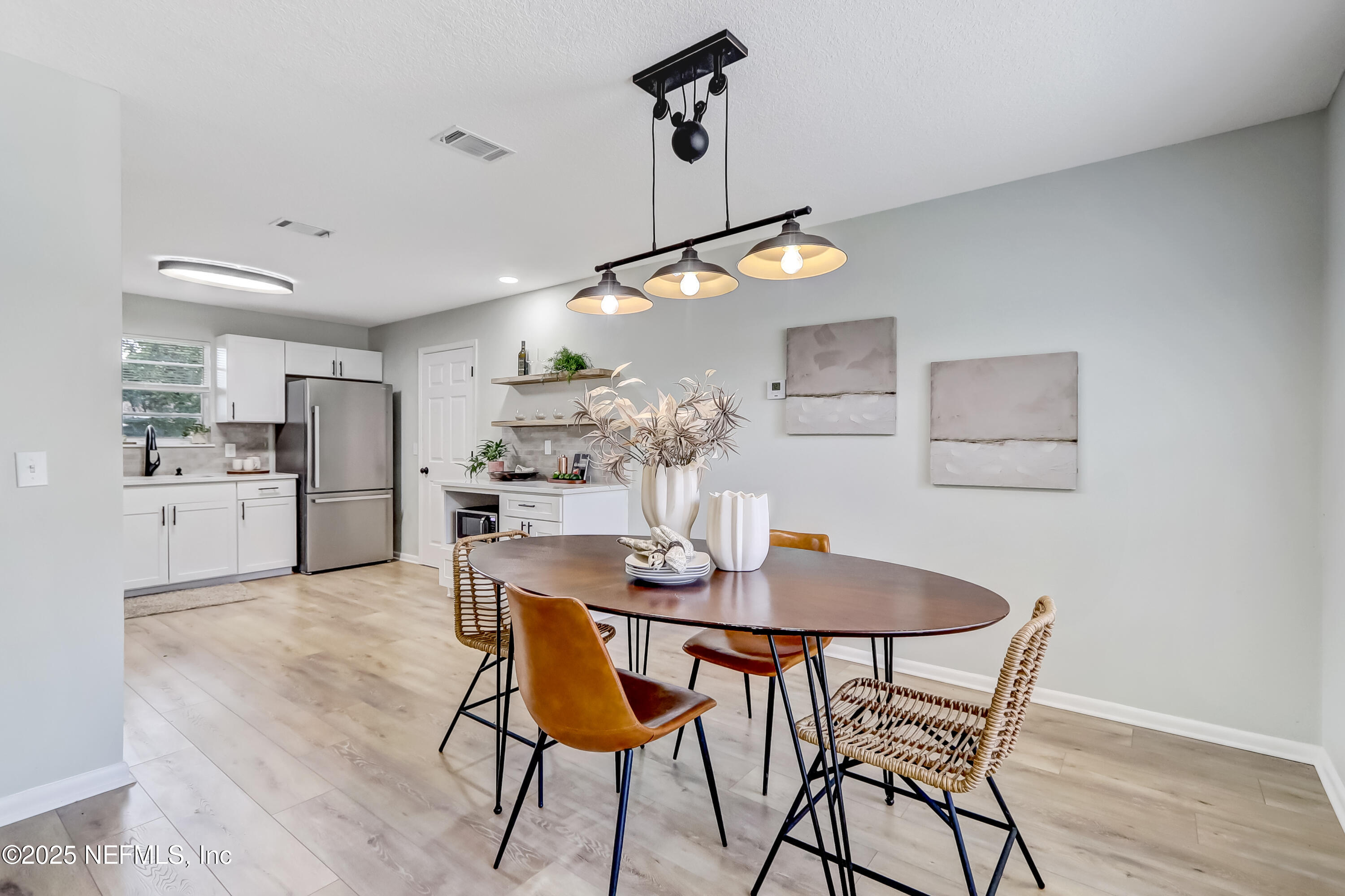 8837 Runnymeade Road Jacksonville, FL 32257 - Photo 18 of 55 a kitchen with stainless steel appliances kitchen island granite countertop a dining table chairs and white cabinets