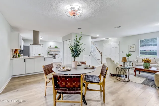 a dining room with furniture a kitchen and chandelier