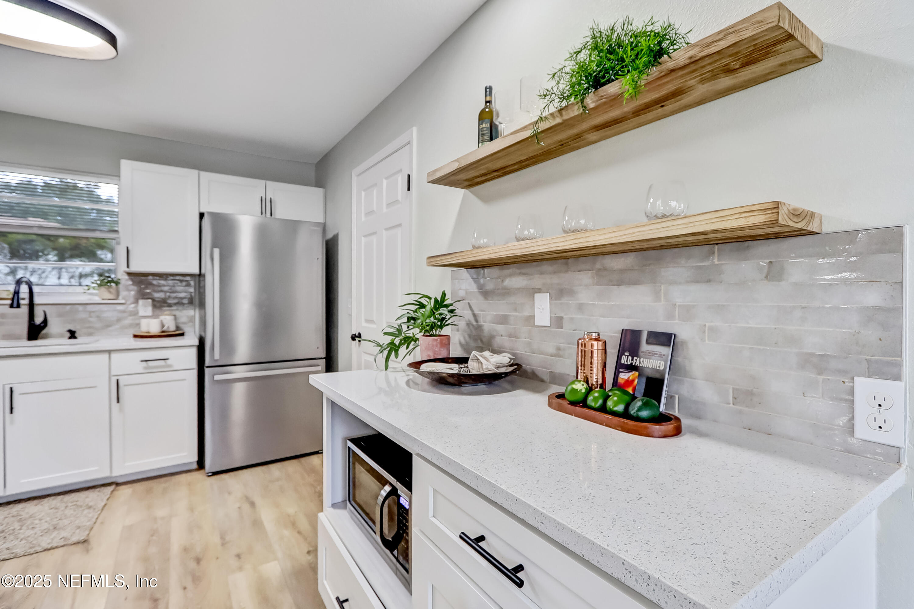 8837 Runnymeade Road Jacksonville, FL 32257 - Photo 22 of 55 a kitchen with stainless steel appliances a sink a refrigerator and a counter top space