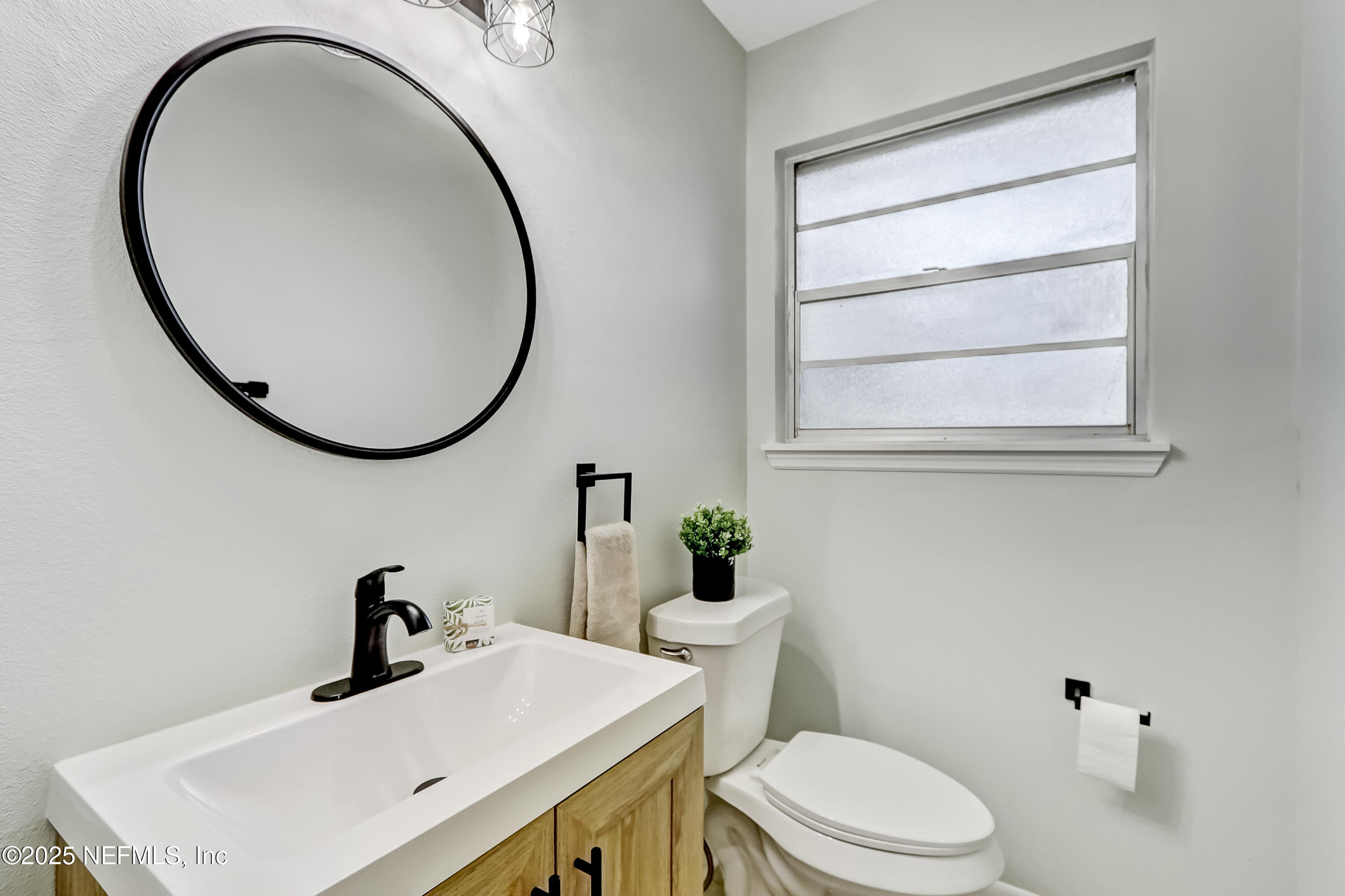 8837 Runnymeade Road Jacksonville, FL 32257 - Photo 30 of 55 a bathroom with a sink a toilet and a mirror