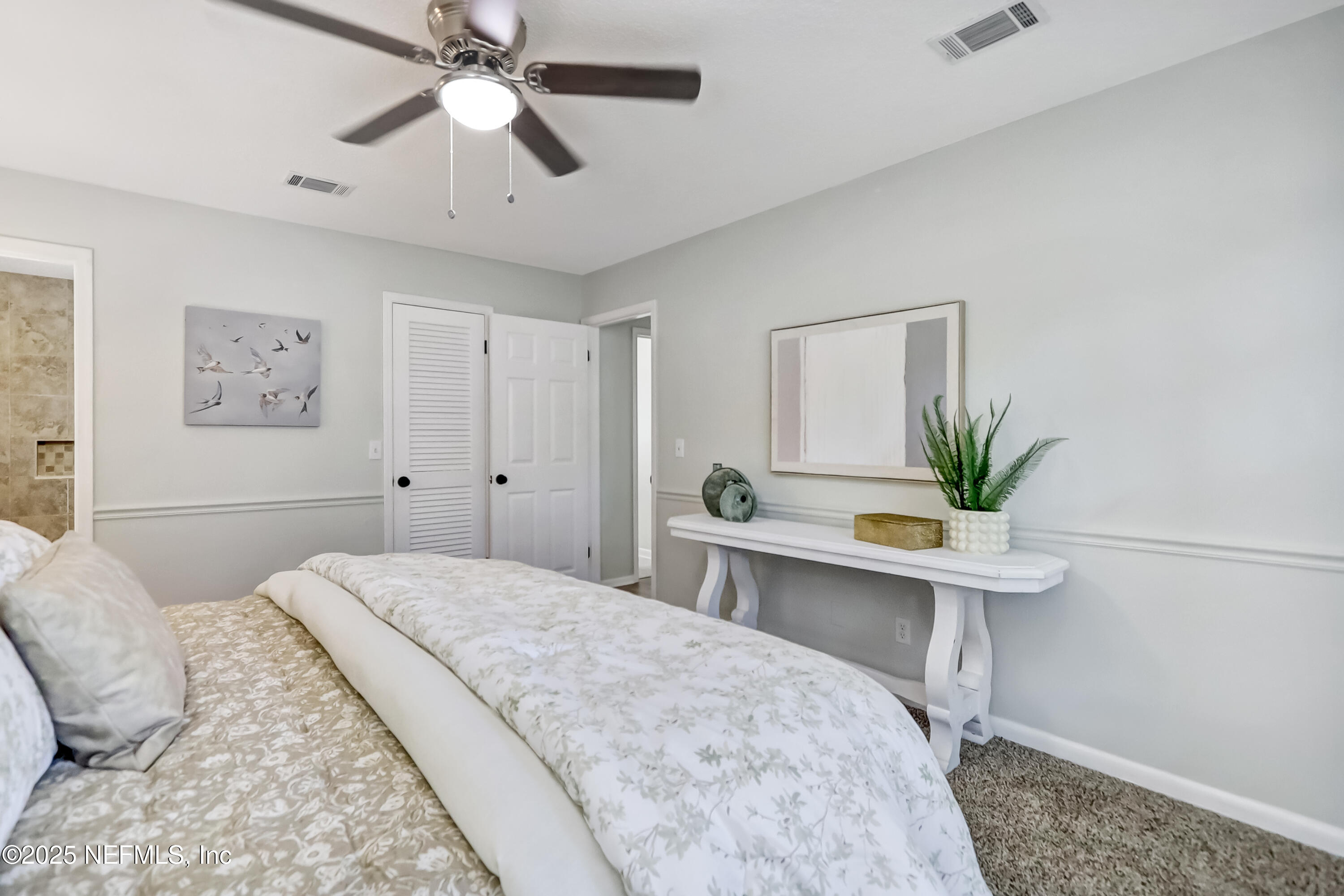 8837 Runnymeade Road Jacksonville, FL 32257 - Photo 33 of 55 a bedroom with a bed and a chandelier