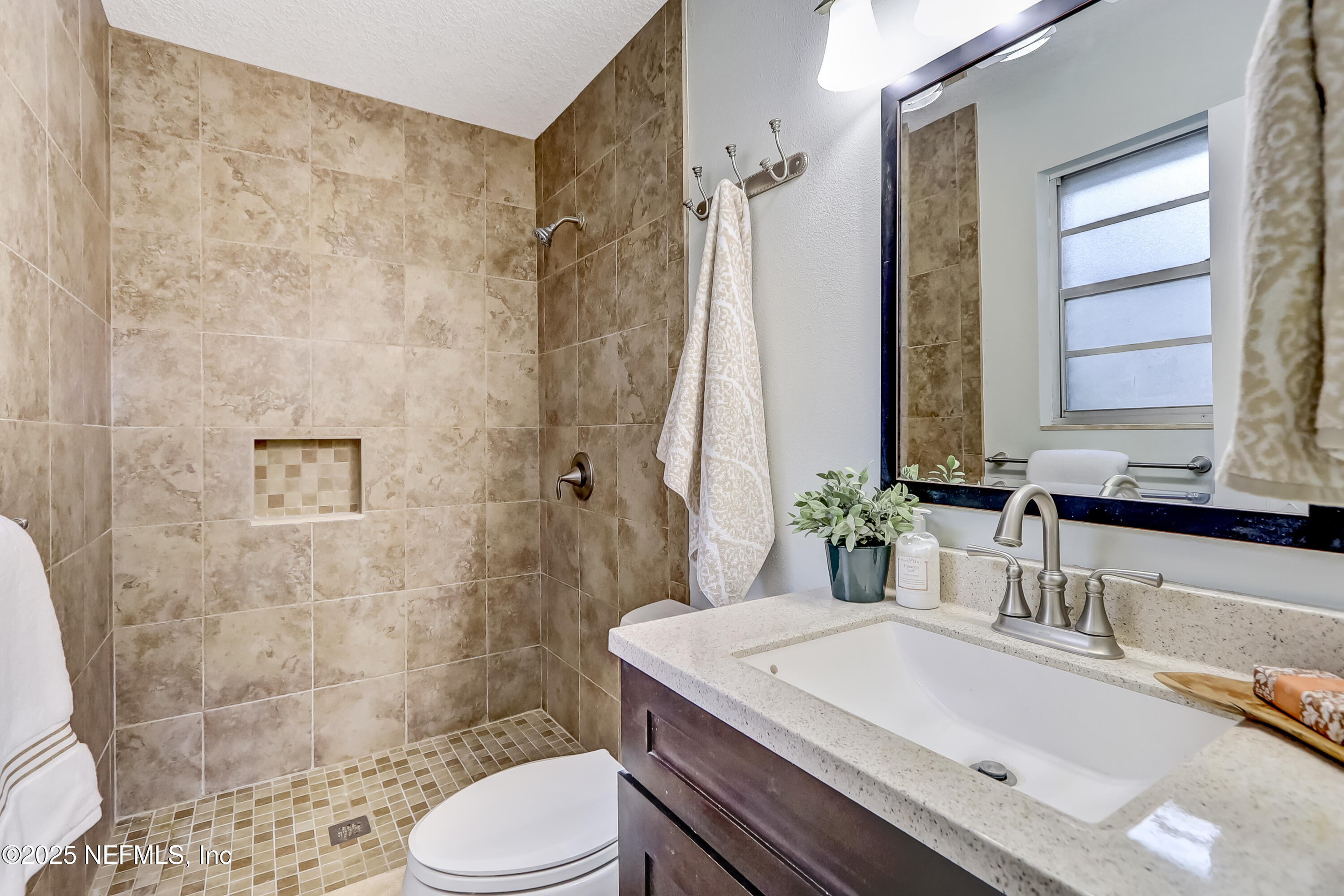 8837 Runnymeade Road Jacksonville, FL 32257 - Photo 35 of 55 a bathroom with a sink toilet vanity and shower