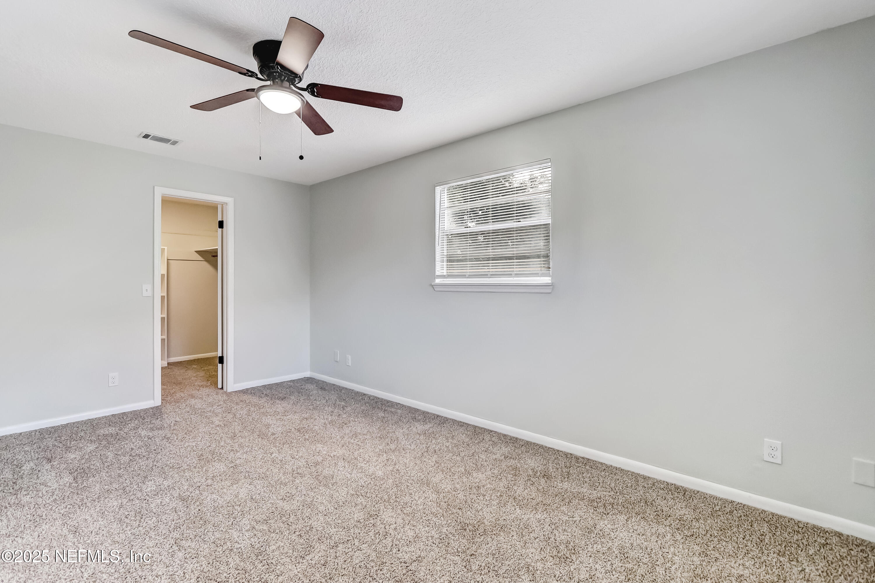 8837 Runnymeade Road Jacksonville, FL 32257 - Photo 44 of 55 an empty room with a window and a fan