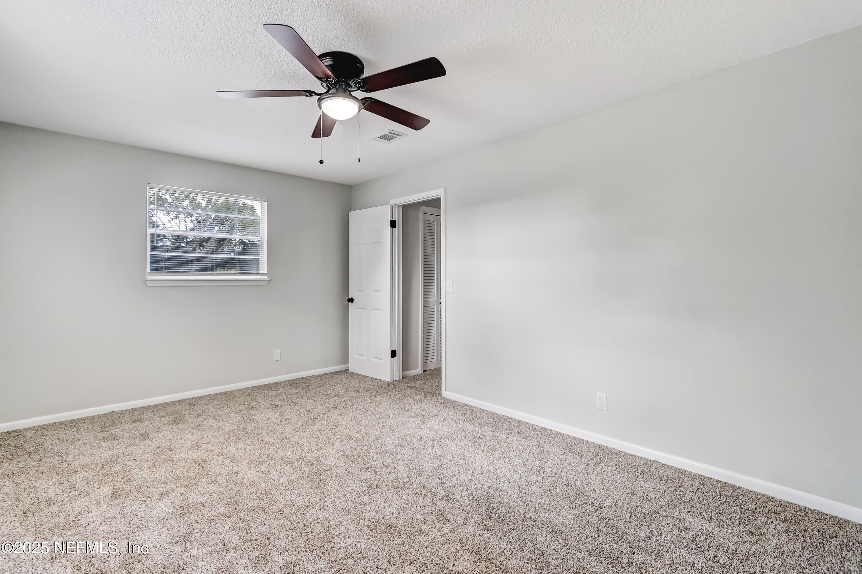8837 Runnymeade Road Jacksonville, FL 32257 - Photo 46 of 55 an empty room with a ceiling fan and a window