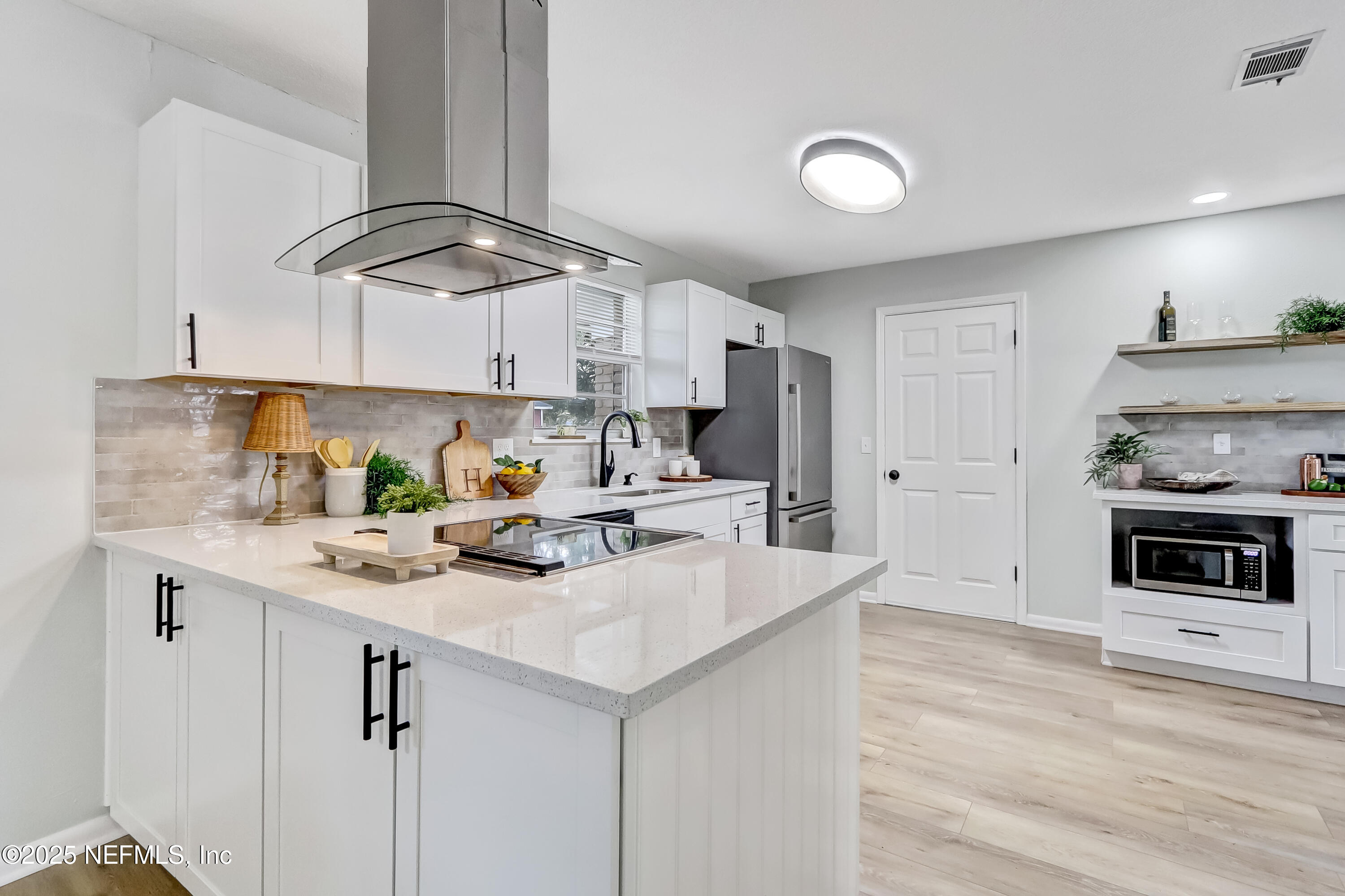 8837 Runnymeade Road Jacksonville, FL 32257 - Photo 9 of 55 a kitchen with stainless steel appliances granite countertop a sink a stove cabinets and wooden floor