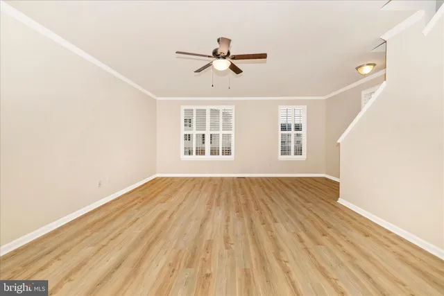 a view of a livingroom with wooden floor and a ceiling fan