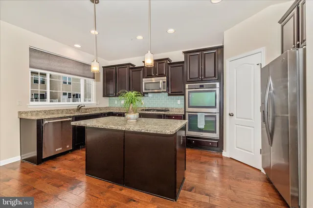 a kitchen with stainless steel appliances granite countertop a stove refrigerator and cabinets