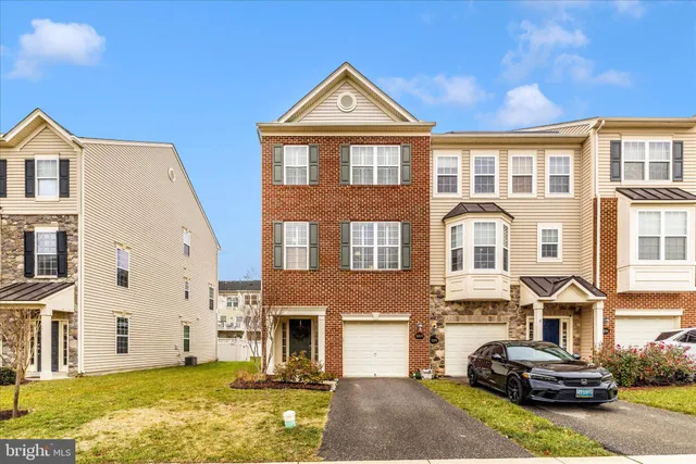 a front view of a house with a yard and potted plants