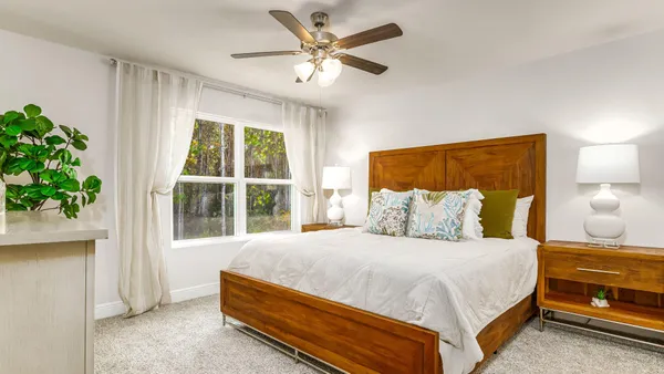 a bedroom with a bed and a large window