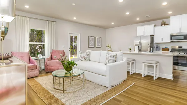 a living room with furniture kitchen and a table
