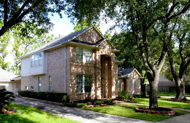 a front view of a house with a yard garage and fountain