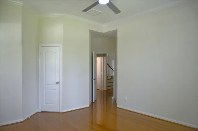 an empty room with closet and a chandelier fan