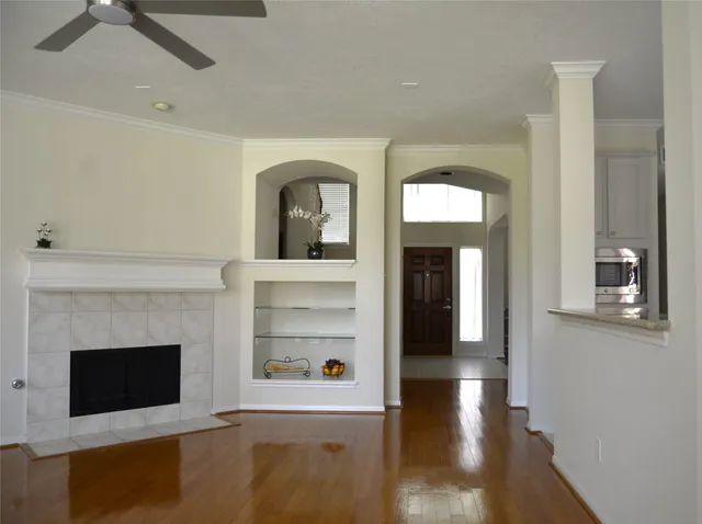 a view of a livingroom with wooden floor and a fireplace