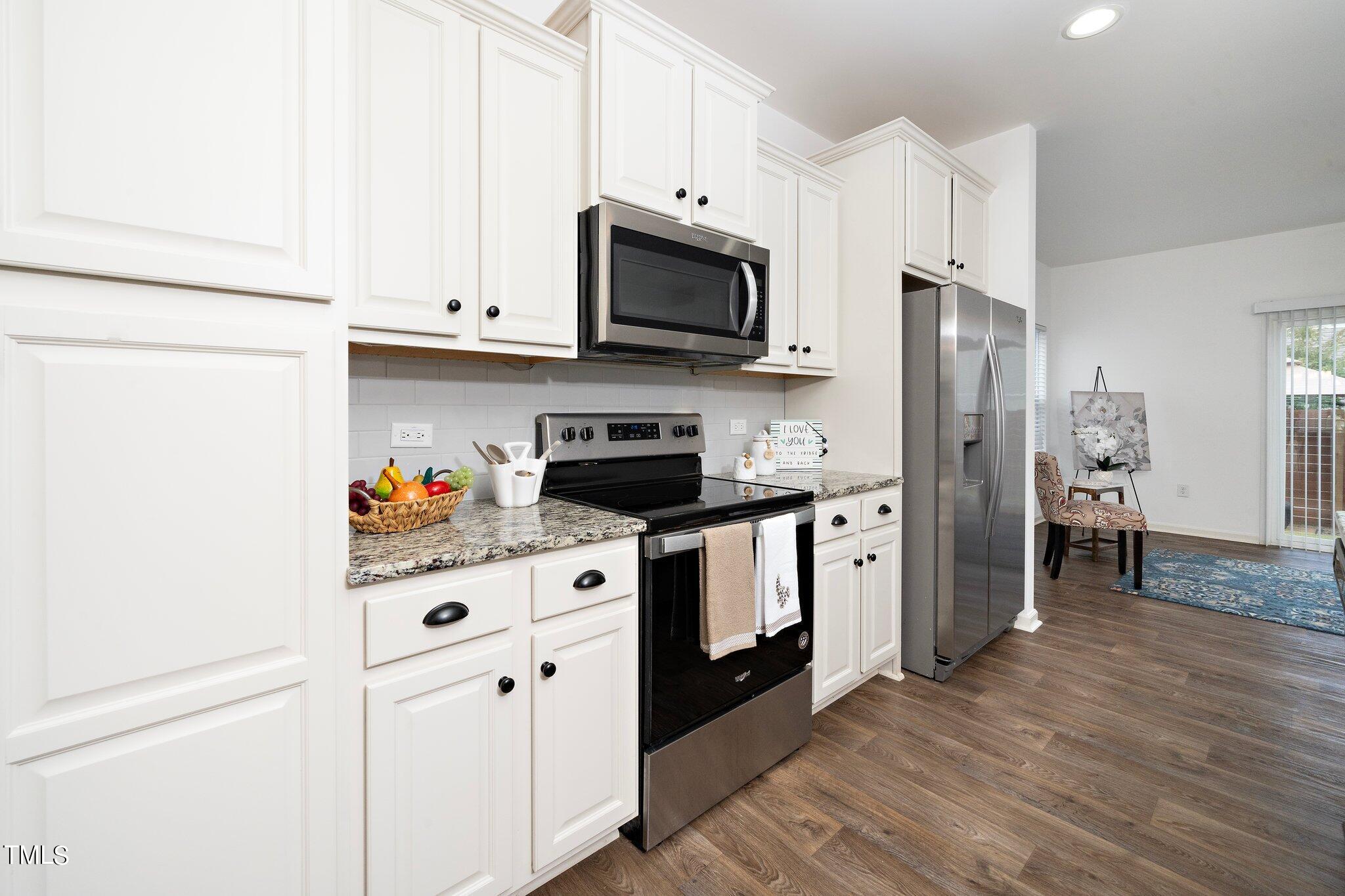 1060 North Gibson Road Mebane, NC 27302 - Photo 14 of 34 a kitchen with stainless steel appliances granite countertop a refrigerator stove and white cabinets