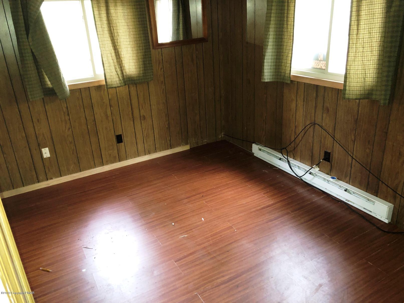 106 Elk Run Road Pocono Lake, PA 18347 - Photo 10 of 11 an empty room with wooden floor and windows