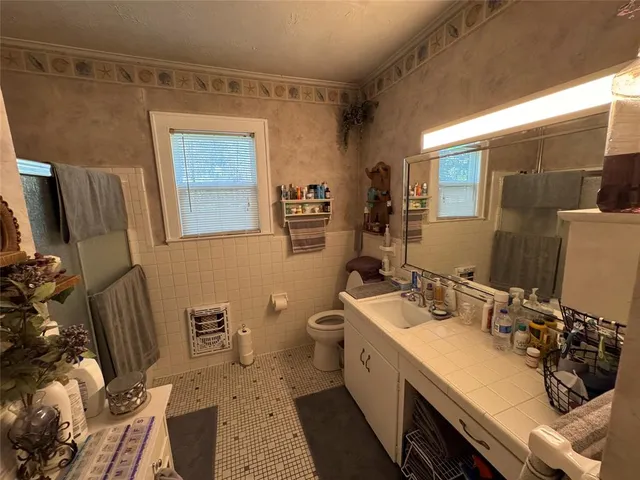 a bathroom with a sink mirror and toilet