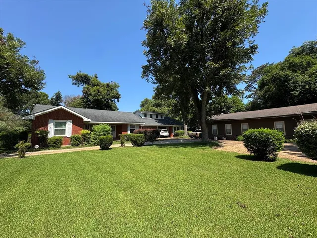 a front view of a house with a yard and trees
