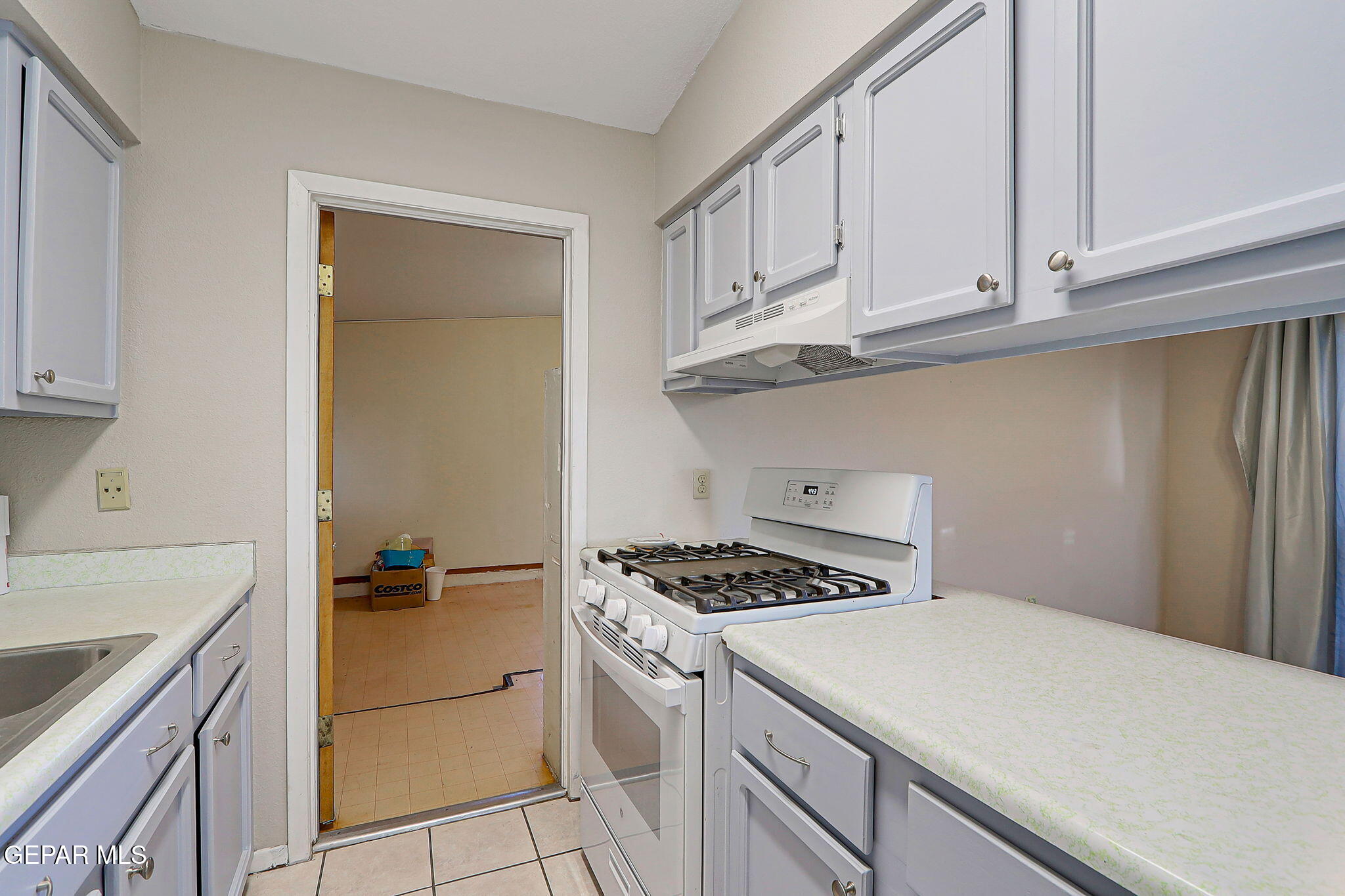 9108 Morelia Road El Paso, TX 79907 - Photo 11 of 35 a kitchen with white cabinets and white appliances