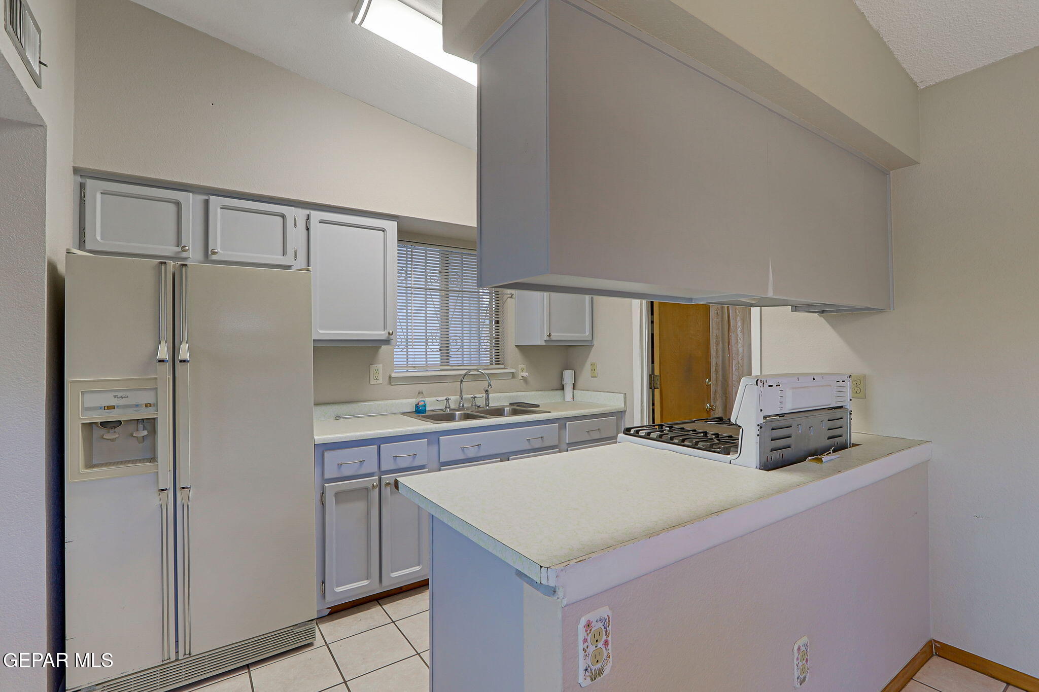 9108 Morelia Road El Paso, TX 79907 - Photo 9 of 35 a kitchen with a refrigerator a sink and cabinets