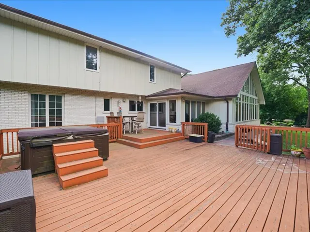 a view of a patio with table and chairs with wooden floor and fence
