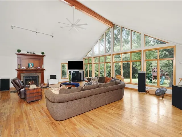a living room with fireplace furniture and a large window