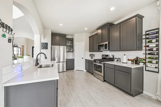 a kitchen with stainless steel appliances granite countertop a sink stove and refrigerator