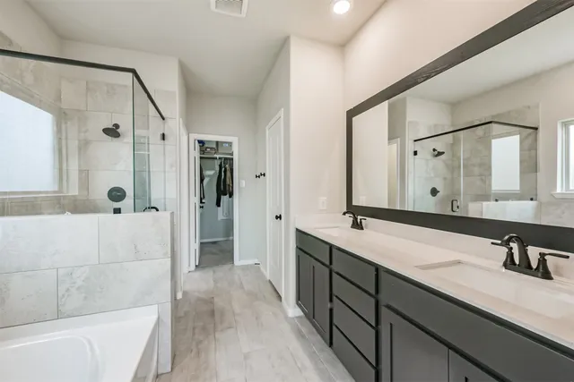 a bathroom with a double vanity sink a large mirror and shower