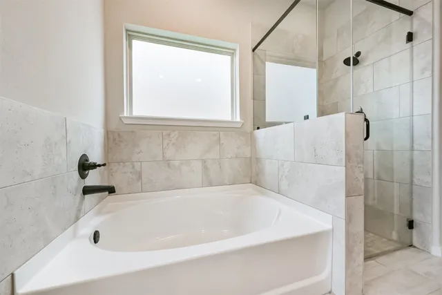 a white bath tub sitting in a bathroom next to a window