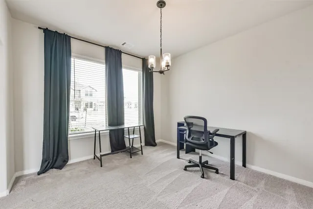 a view of a workspace with furniture and a window