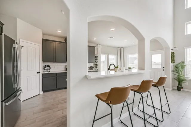 a large kitchen with stainless steel appliances a large counter top a stove a refrigerator and a sink