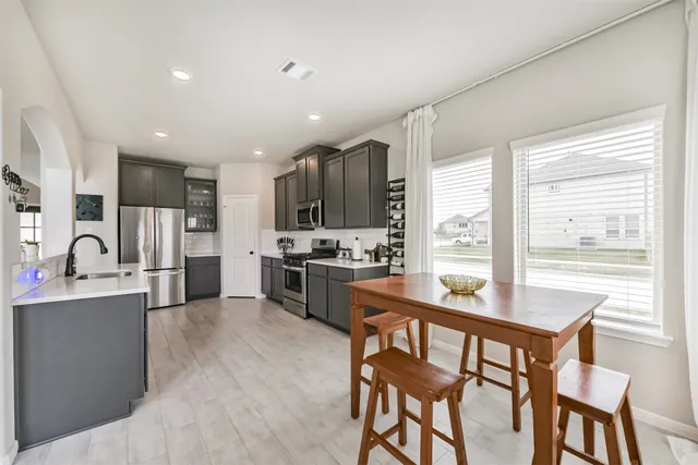 a kitchen with stainless steel appliances granite countertop a stove refrigerator sink and cabinets