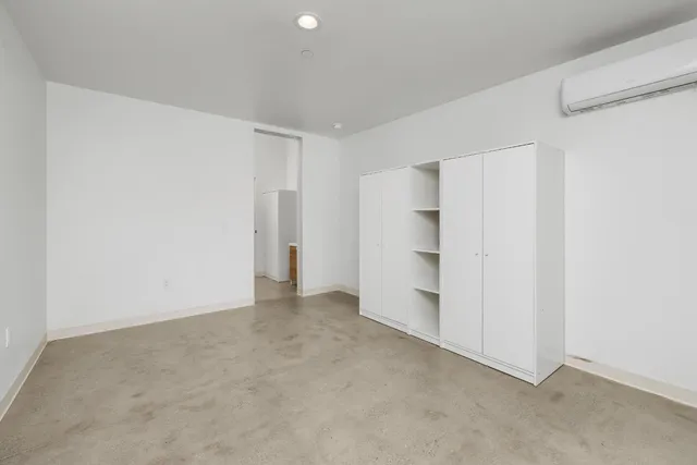an empty room with windows and closet