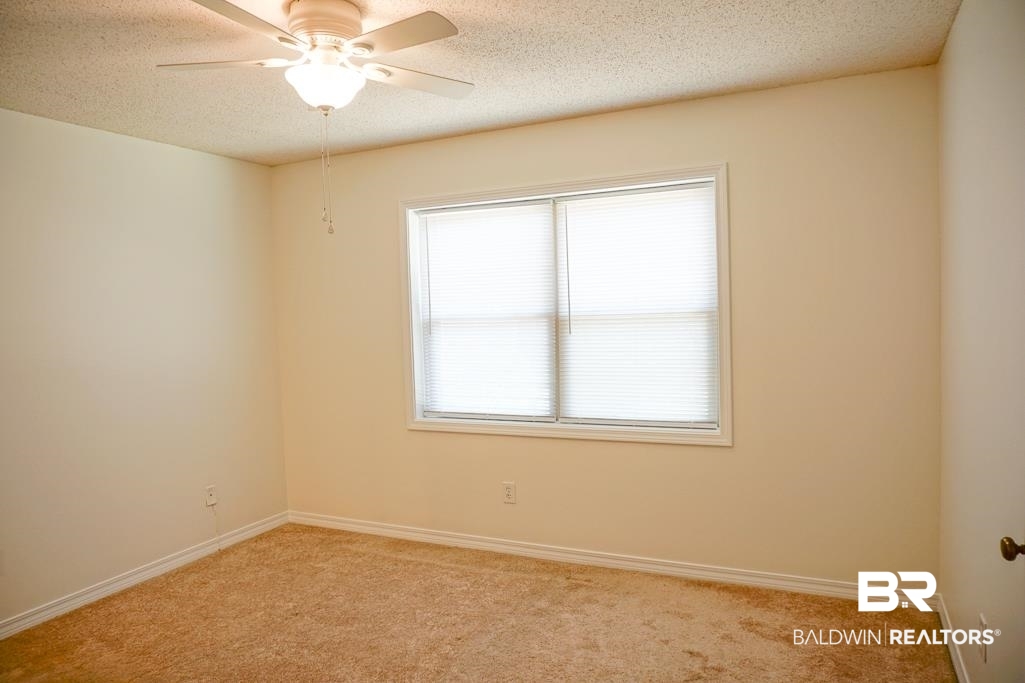 4377 Fathbrook Lane Mobile, AL 36693 - Photo 10 of 19 Unfurnished room featuring baseboards, a textured ceiling, a ceiling fan, and light carpet