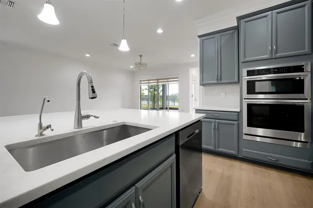 a kitchen with a sink cabinets and wooden floor