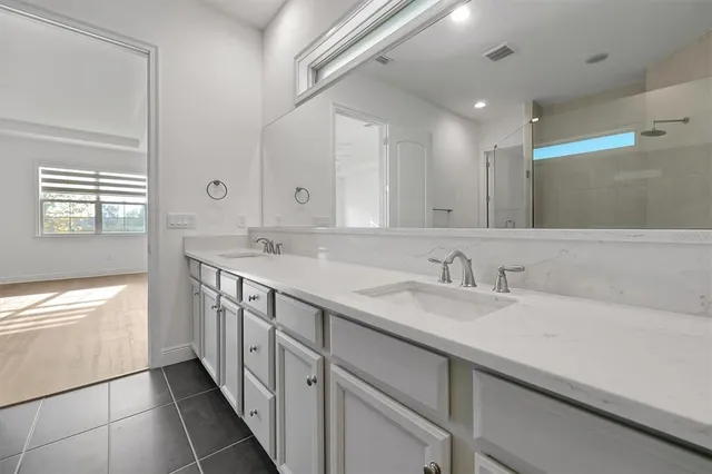 a bathroom with a double vanity sink and a mirror