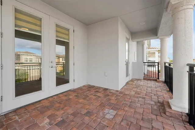 an empty room with wooden floor chandelier fan and windows
