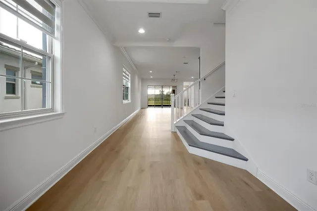 a view of entryway and hall with wooden floor