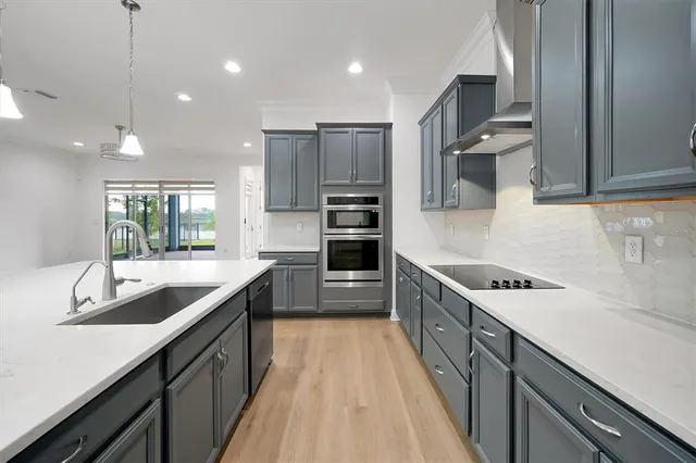 a kitchen with kitchen island granite countertop a sink stove and refrigerator