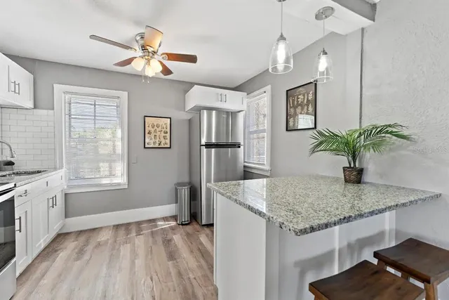 a kitchen with stainless steel appliances kitchen island granite countertop a refrigerator a stove a microwave and cabinets