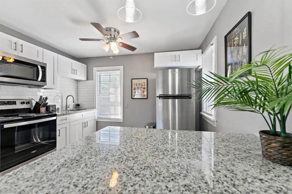 3320 18th Street North St. Petersburg, FL 33713 - Photo 21 of 28 a kitchen with stainless steel appliances kitchen island granite countertop a refrigerator a stove a microwave and cabinets