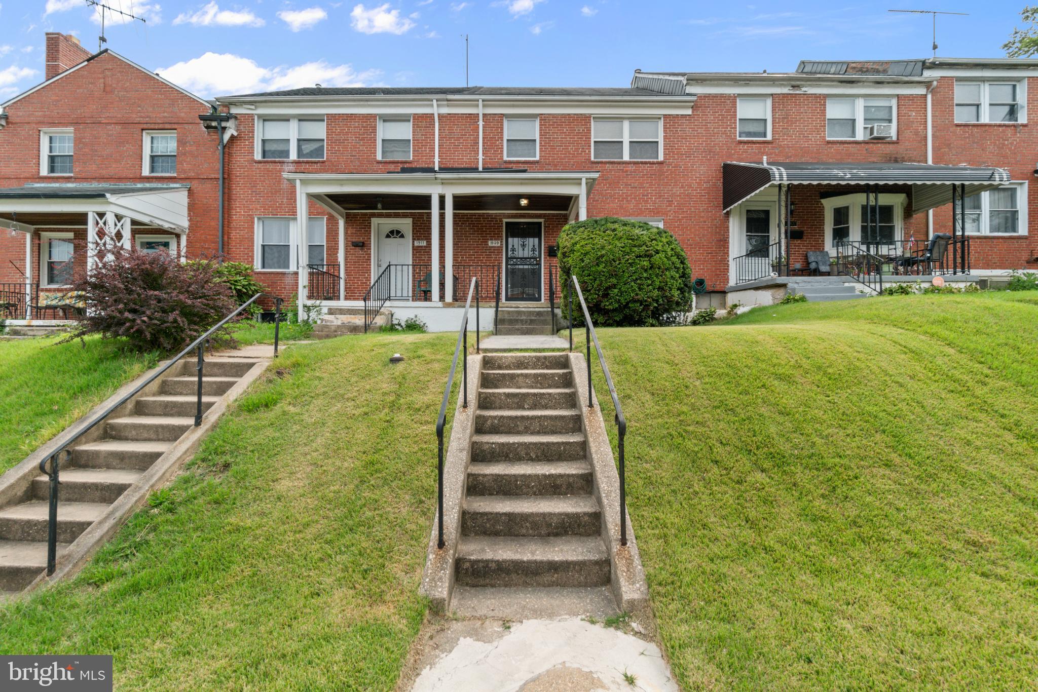 a front view of a house with a yard and plants