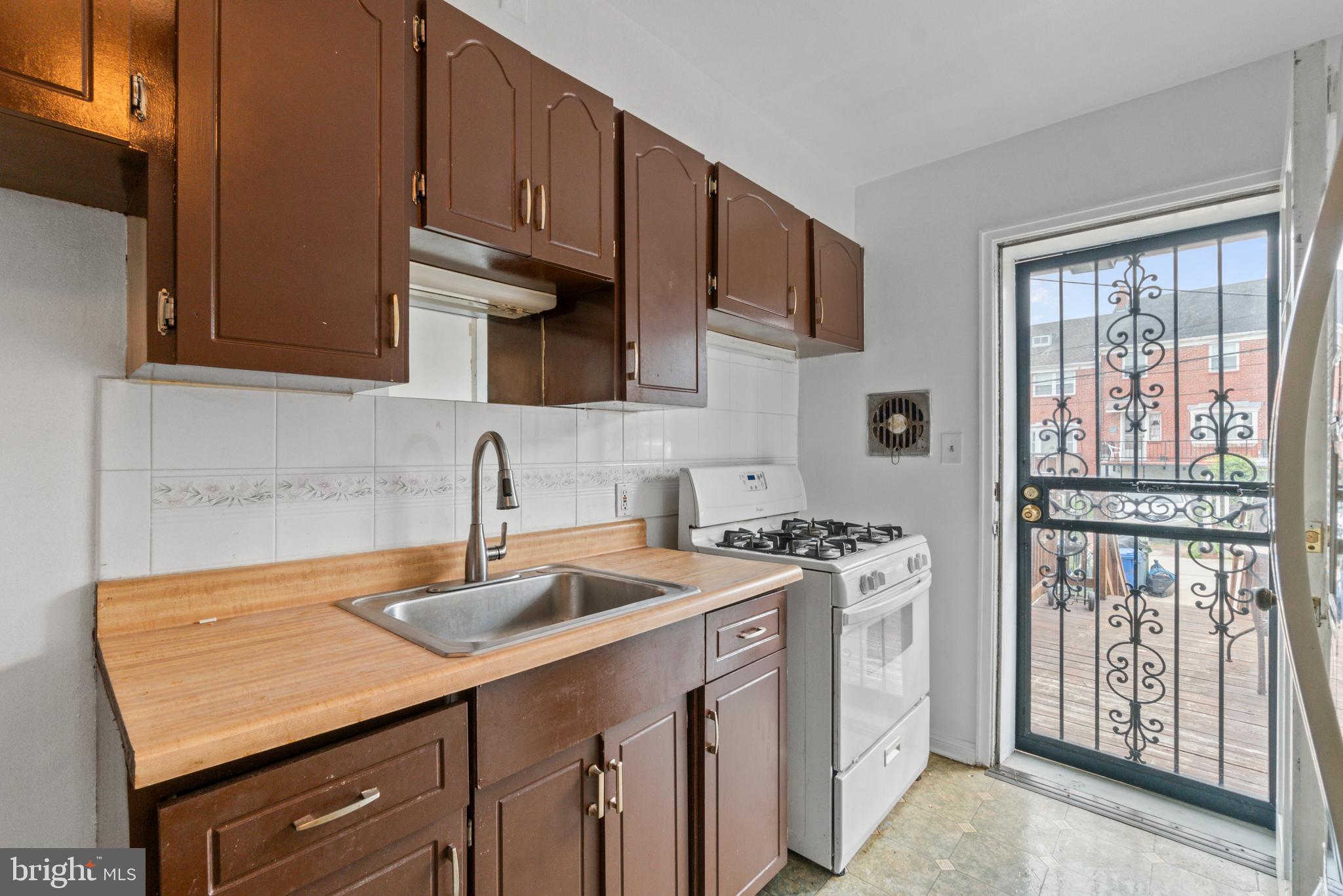 1909 Heathfield Road Baltimore, MD 21239 - Photo 6 of 22 a kitchen with stainless steel appliances granite countertop a sink stove and cabinets