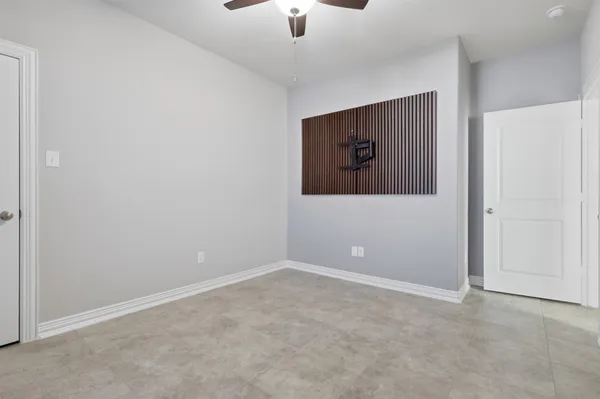 a view of an empty room with a ceiling fan