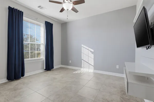 a view of an empty room with a flat screen tv and a window