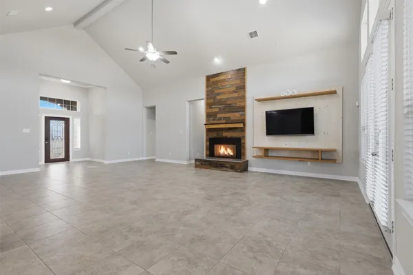 a view of an empty room with a fireplace and a window
