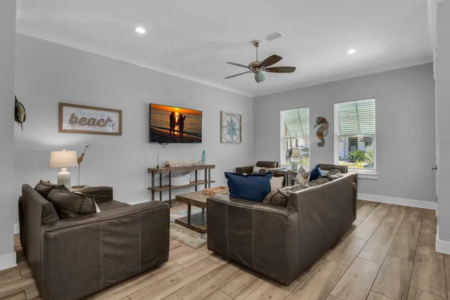 a living room with couches and a flat screen tv with wooden floor